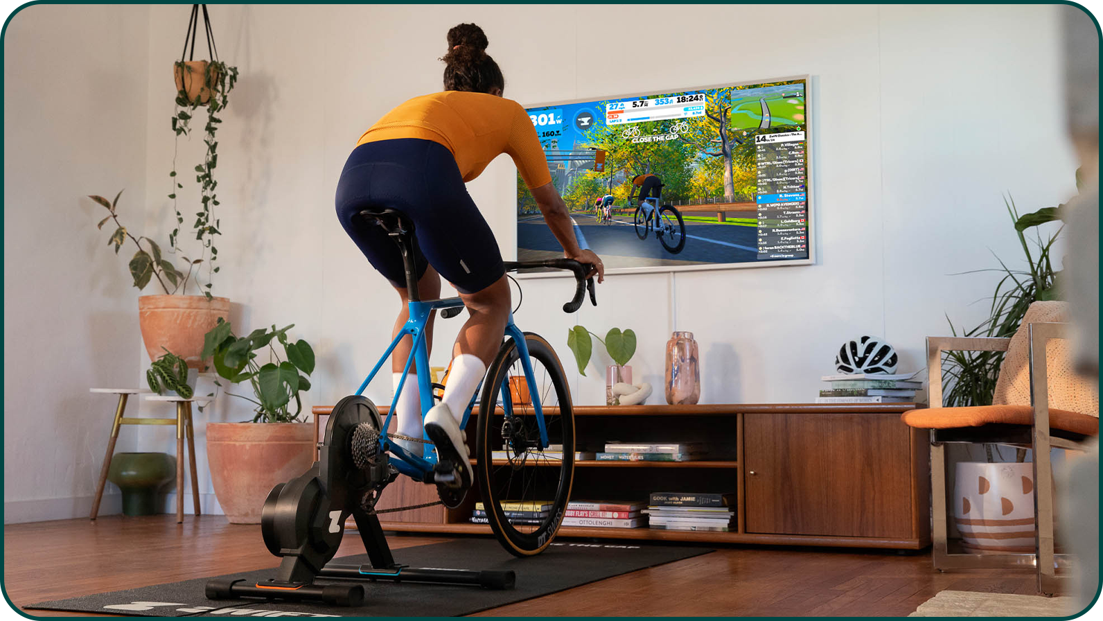 Cycliste s'entrainant sur un home trainer dans son salon sur la plateforme Zwift